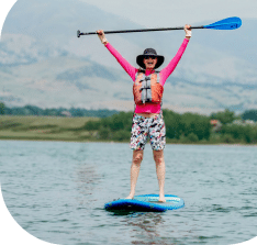 woman on a stand up paddle board on a lake