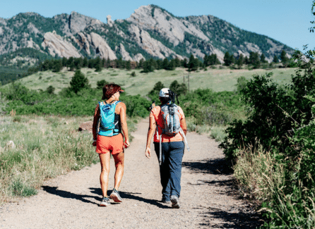 two women hiking toward mountains in Colorado