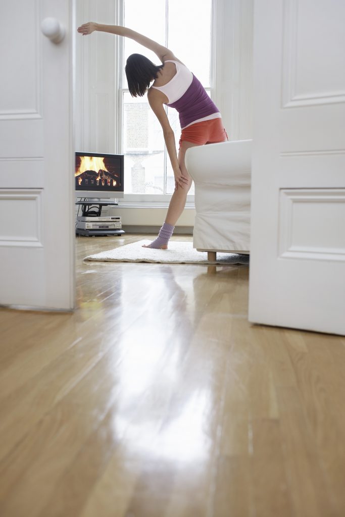 Woman Exercising and Watching Television in Living Room